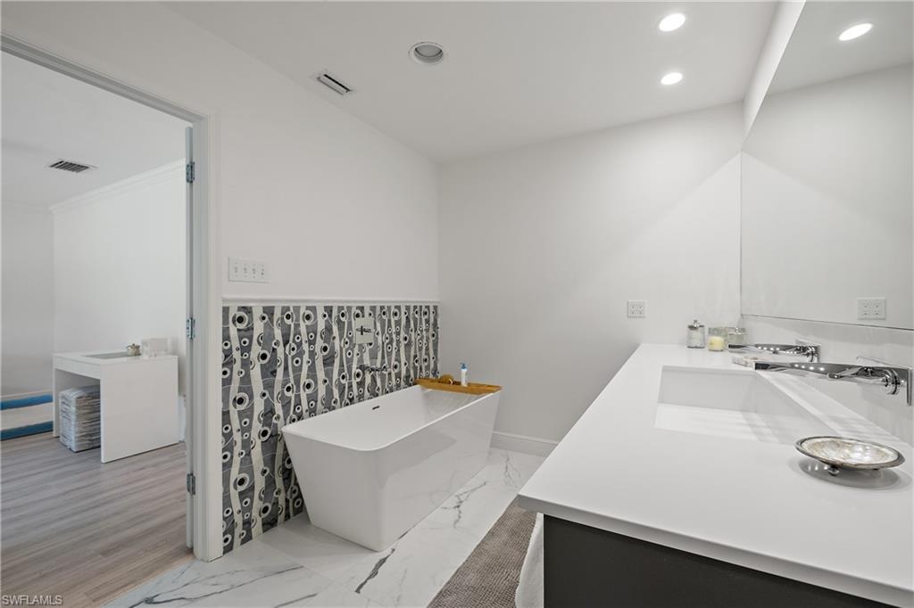 540 Rudder Road Naples, FL 34102 - Photo 28 of 37 Full bathroom featuring a freestanding tub, recessed lighting, a sink, visible vents, and double vanity