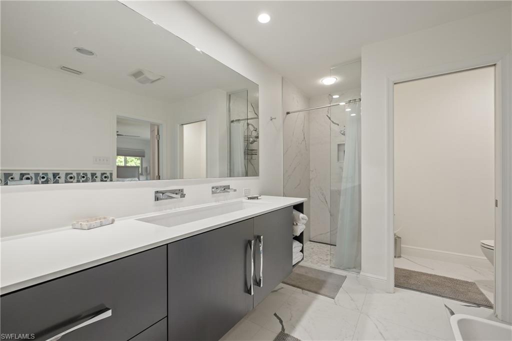 540 Rudder Road Naples, FL 34102 - Photo 29 of 37 Bathroom with a marble finish shower, marble finish floor, vanity, and toilet