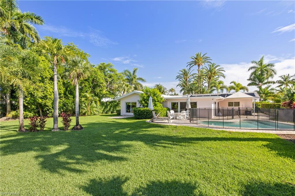 540 Rudder Road Naples, FL 34102 - Photo 4 of 37 View of yard featuring fence, a patio, and a fenced in pool