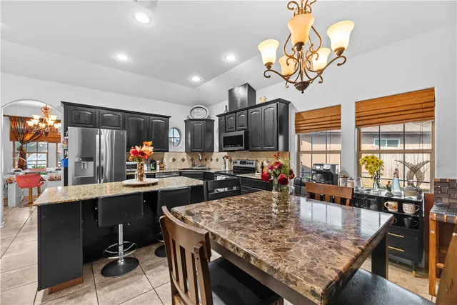 a kitchen with a table chairs stove and refrigerator