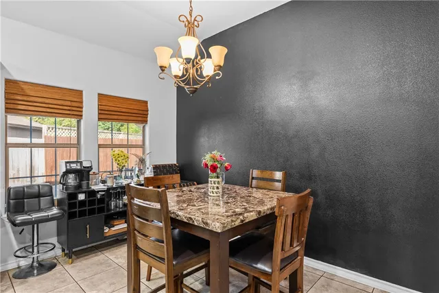 a view of a dining room with furniture a chandelier and a window