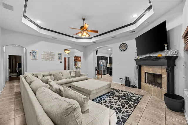 a living room with furniture a flat screen tv and a fireplace