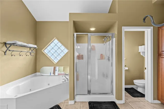 a bathroom with a bathtub shower sink mirror and toilet