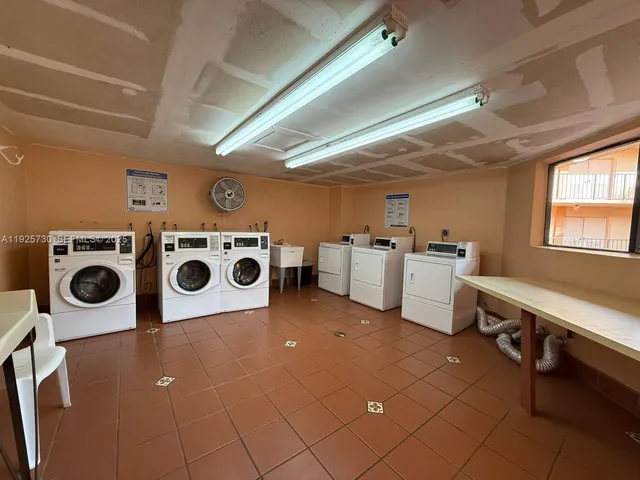a utility room with dryer washer and a view of living room