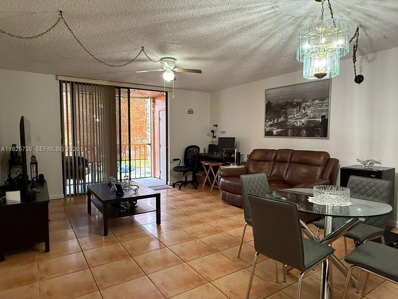 8600 Southwest 133rd Avenue Road, Unit 310 Miami, FL 33183 - Photo 2 of 22 a living room with furniture a chandelier and a dining table