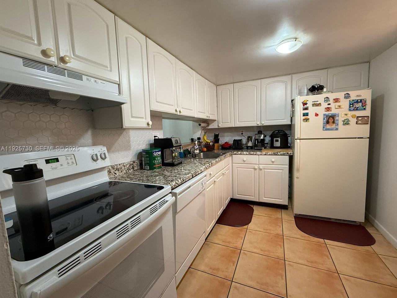 8600 Southwest 133rd Avenue Road, Unit 310 Miami, FL 33183 - Photo 3 of 22 a kitchen with cabinets a sink and white appliances
