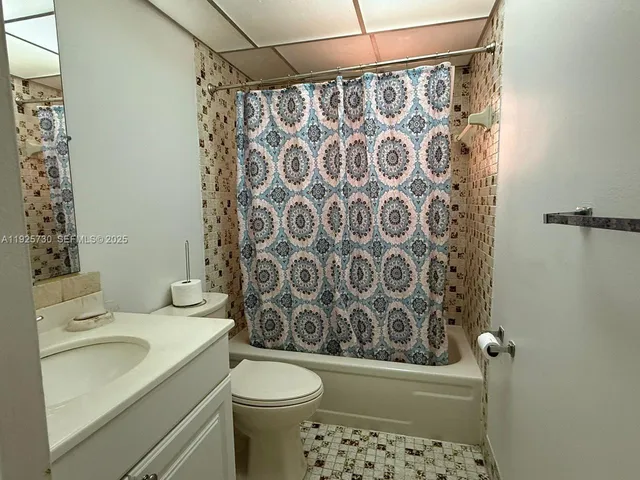 a bathroom with a shower curtain and a toilet