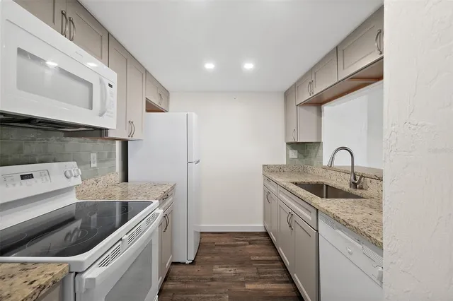 a kitchen with a sink a refrigerator and cabinets