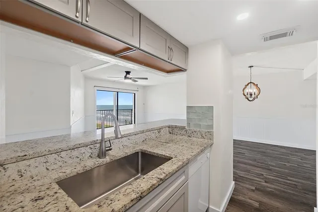a kitchen with granite countertop a sink and a stove
