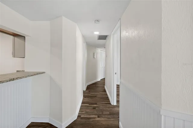 a view of a hallway with wooden floor