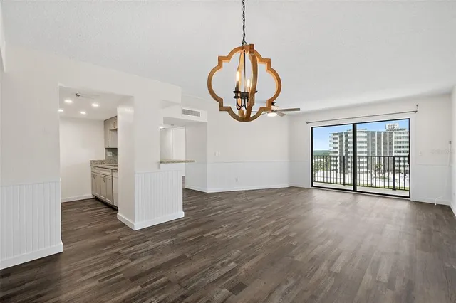 a view of a room with wooden floor mirror and windows