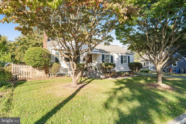 a view of swimming pool with outdoor seating and trees in the background