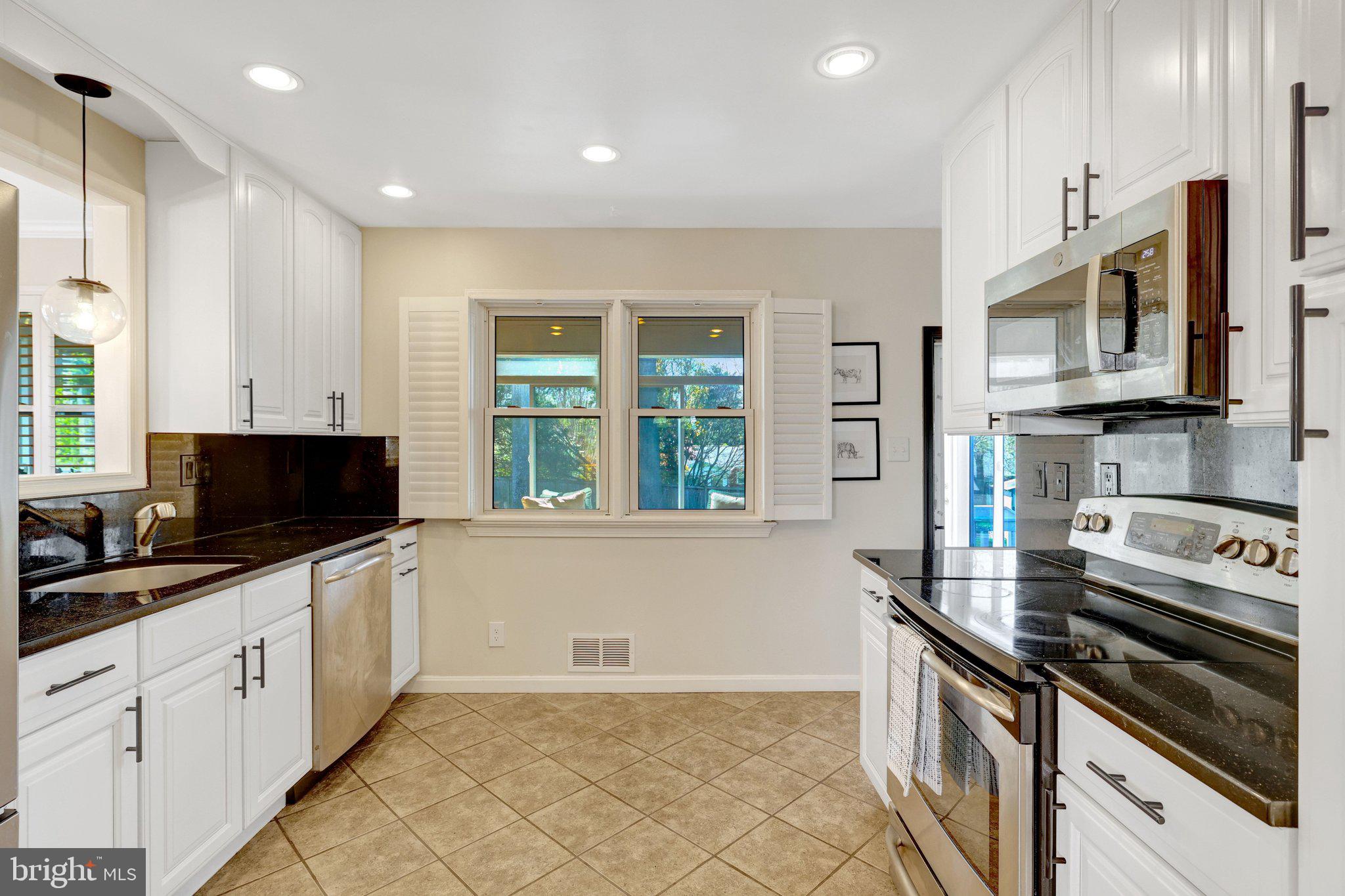 4132 Addison Road Fairfax, VA 22030 - Photo 17 of 58 a kitchen with stainless steel appliances a stove sink microwave and cabinets