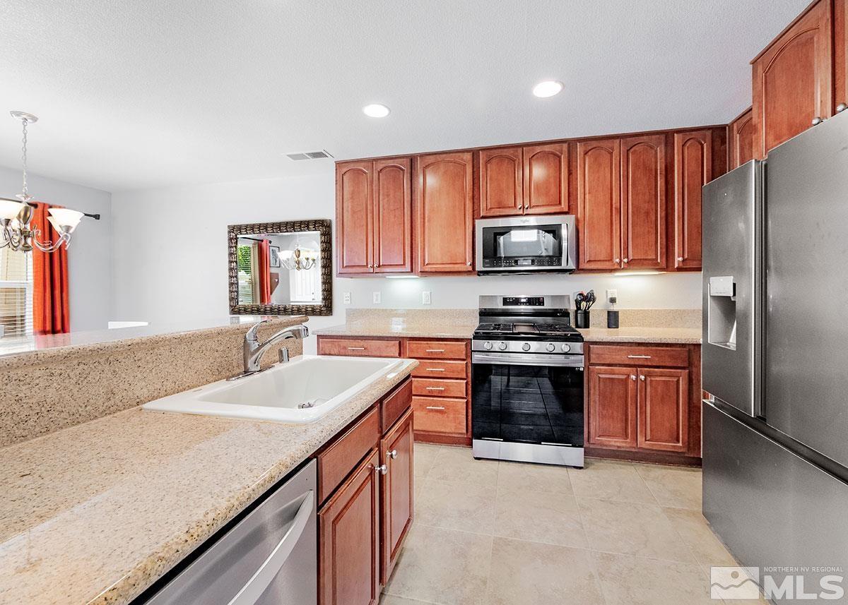 1633 Clover Hill Trail Reno, NV 89523 - Photo 8 of 37 a kitchen with granite countertop a stove cabinets and refrigerator