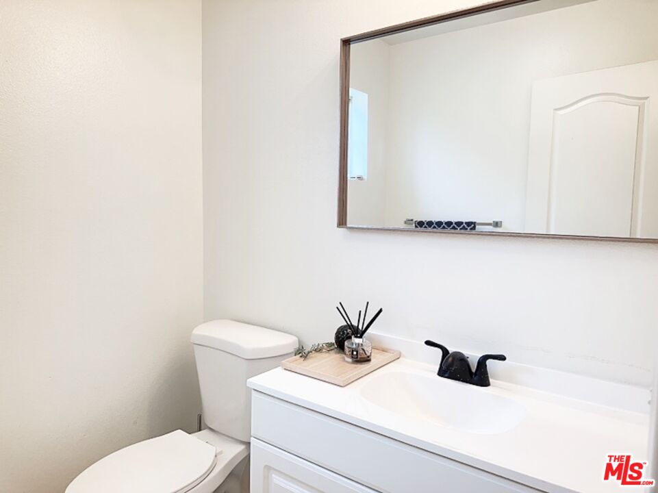 7864 Stewart And Gray Road Downey, CA 90241 - Photo 15 of 25 a bathroom with a sink a toilet and mirror