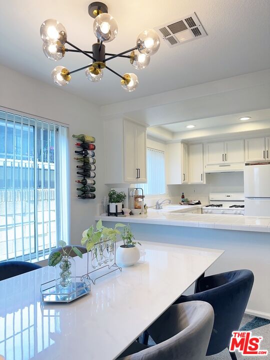 7864 Stewart And Gray Road Downey, CA 90241 - Photo 10 of 25 a kitchen with a table chairs stove and cabinets