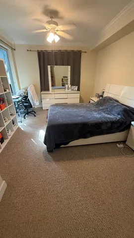 a bedroom with a bed gym equipment and view of living room