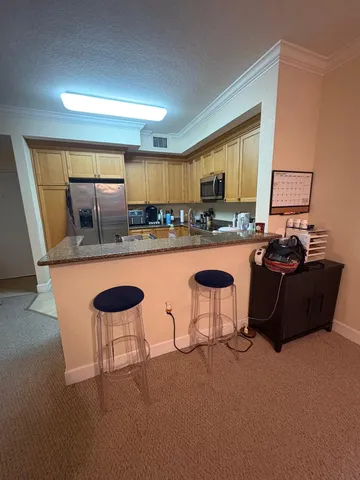 a kitchen with a table chairs refrigerator and a sink