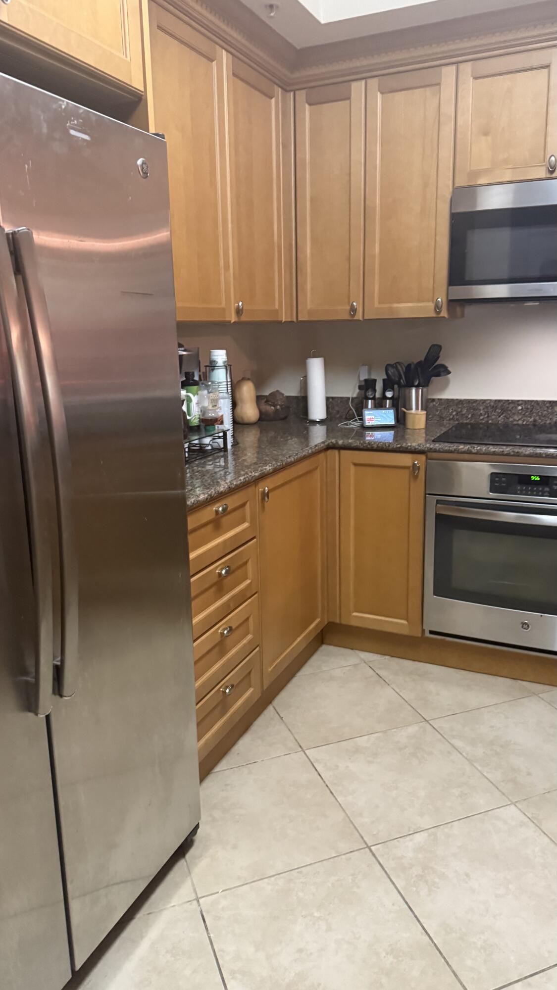 1690 Renaissance Commons Boulevard, Unit 1427 Boynton Beach, FL 33426 - Photo 6 of 20 a kitchen with stainless steel appliances granite countertop a refrigerator and a stove