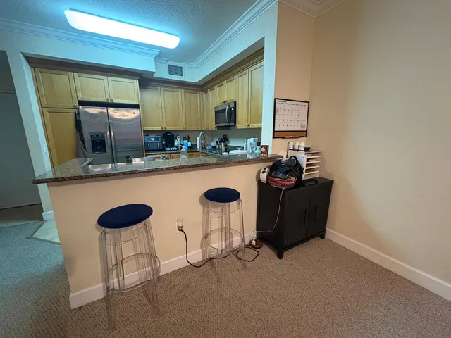 a kitchen with a sink and chairs