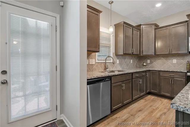 a kitchen with granite countertop a sink and cabinets