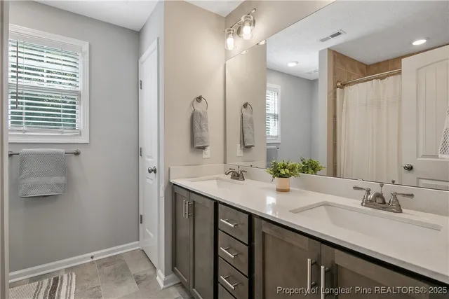 a bathroom with double sink and a mirror