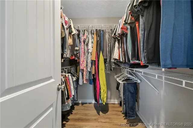 a view of walk in closet with clothes