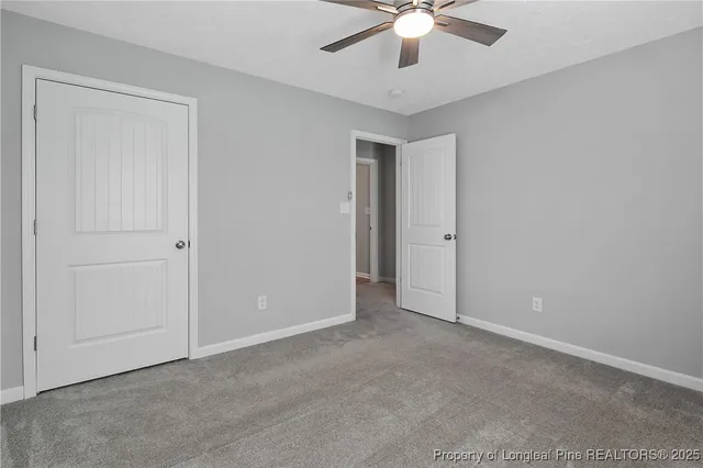 an empty room with chandelier fan