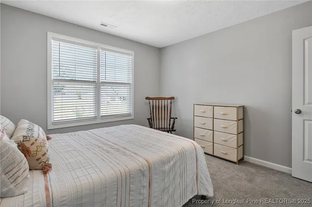 a bedroom with a bed a window and cabinet