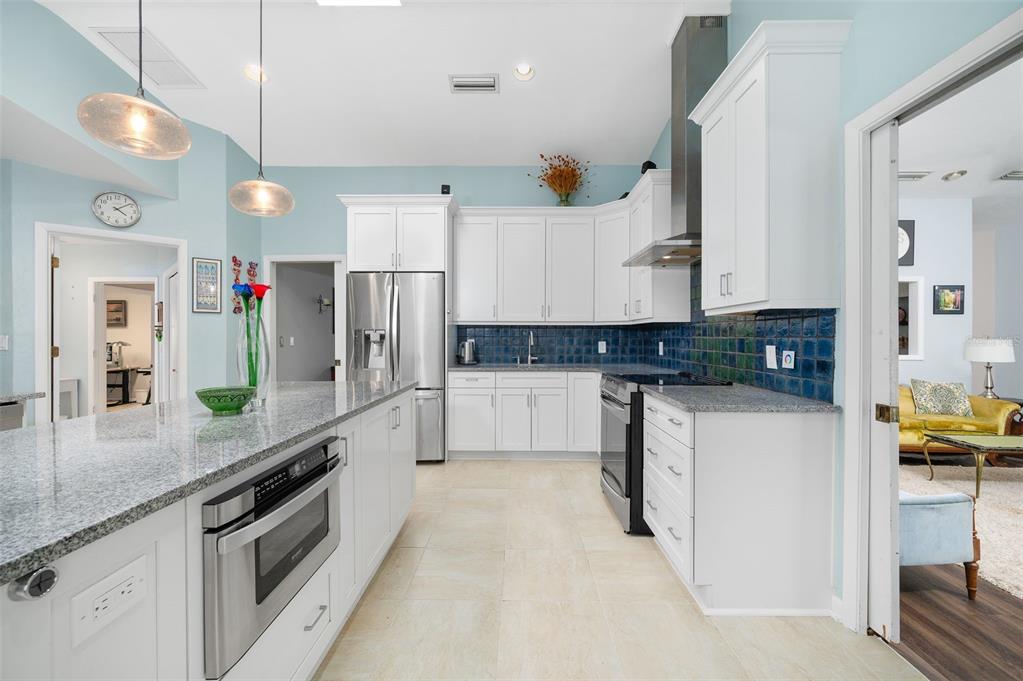 9923 Southwest 2nd Place Gainesville, FL 32607 - Photo 19 of 73 a large kitchen with stainless steel appliances granite countertop a refrigerator a stove and a sink