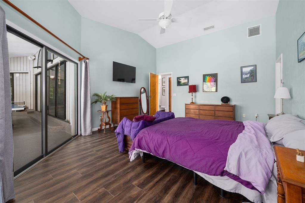 9923 Southwest 2nd Place Gainesville, FL 32607 - Photo 24 of 73 a bedroom with a bed wooden floor and flat screen tv