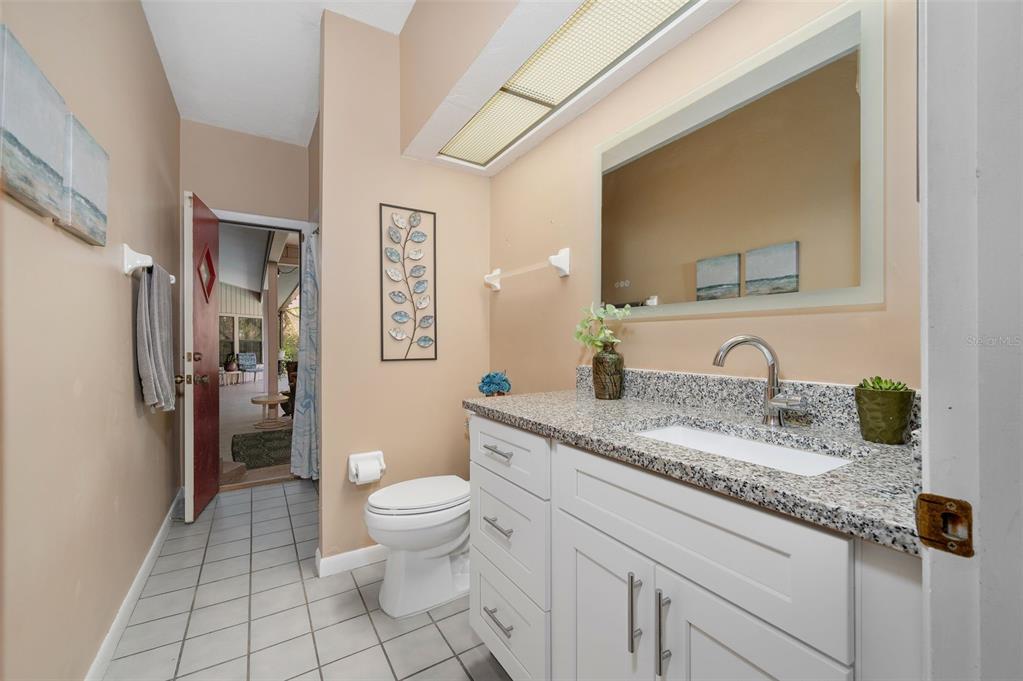 9923 Southwest 2nd Place Gainesville, FL 32607 - Photo 42 of 73 a bathroom with a granite countertop sink a toilet and a mirror