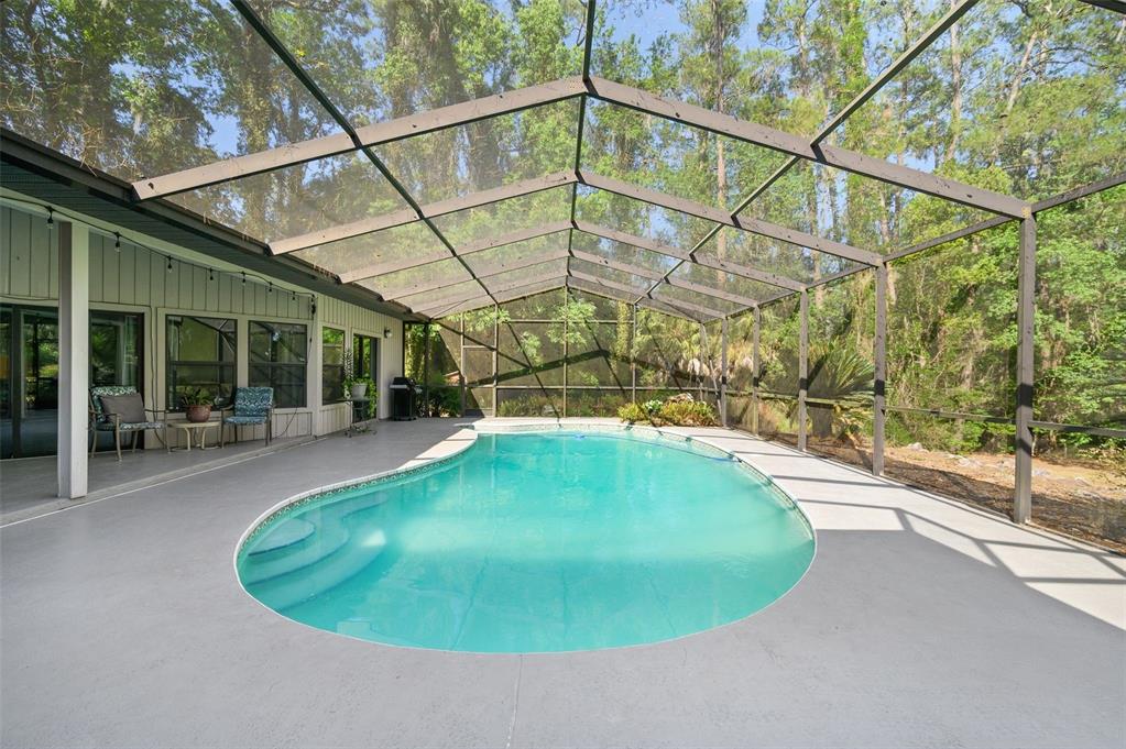 9923 Southwest 2nd Place Gainesville, FL 32607 - Photo 51 of 73 a view of a swimming pool with a patio and a yard