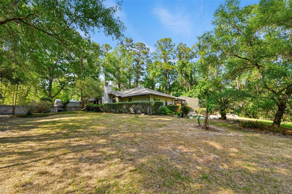 9923 Southwest 2nd Place Gainesville, FL 32607 - Photo 64 of 73 a yellow house with trees in front of it