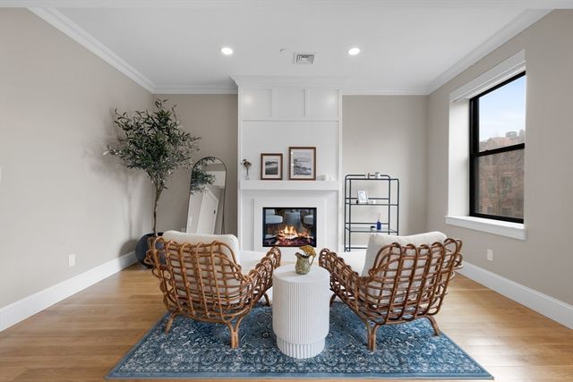 a living room with furniture a fireplace and a potted plant