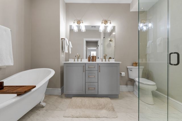 a spacious bathroom with a toilet a sink and a mirror