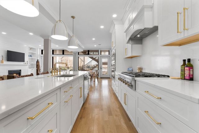 a large kitchen with stainless steel appliances granite countertop a lot of counter space and wooden floors
