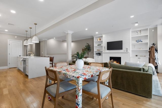 a view of a dining room with furniture a fireplace and wooden floor