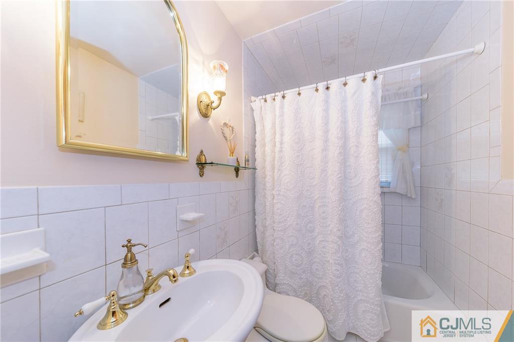 26 Middlesex Road Matawan, NJ 07747 - Photo 4 of 23 a bathroom with a sink a toilet and shower curtain