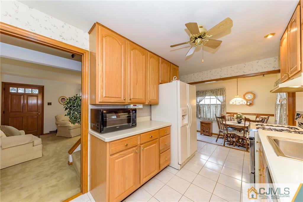 26 Middlesex Road Matawan, NJ 07747 - Photo 6 of 23 a kitchen with stainless steel appliances a stove a refrigerator cabinets and living room view