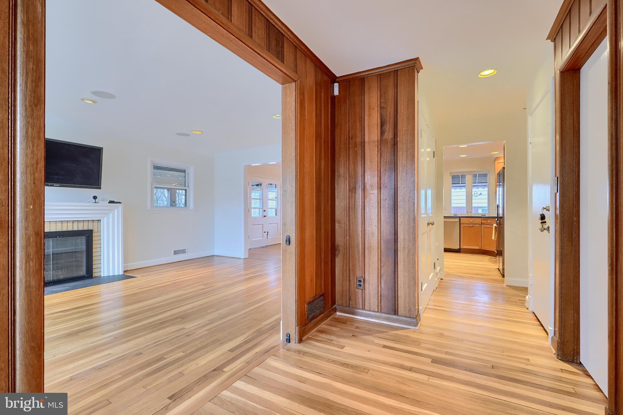 9715 Saxony Road Silver Spring, MD 20910 - Photo 5 of 31 a view of a hallway with wooden floor and a fireplace
