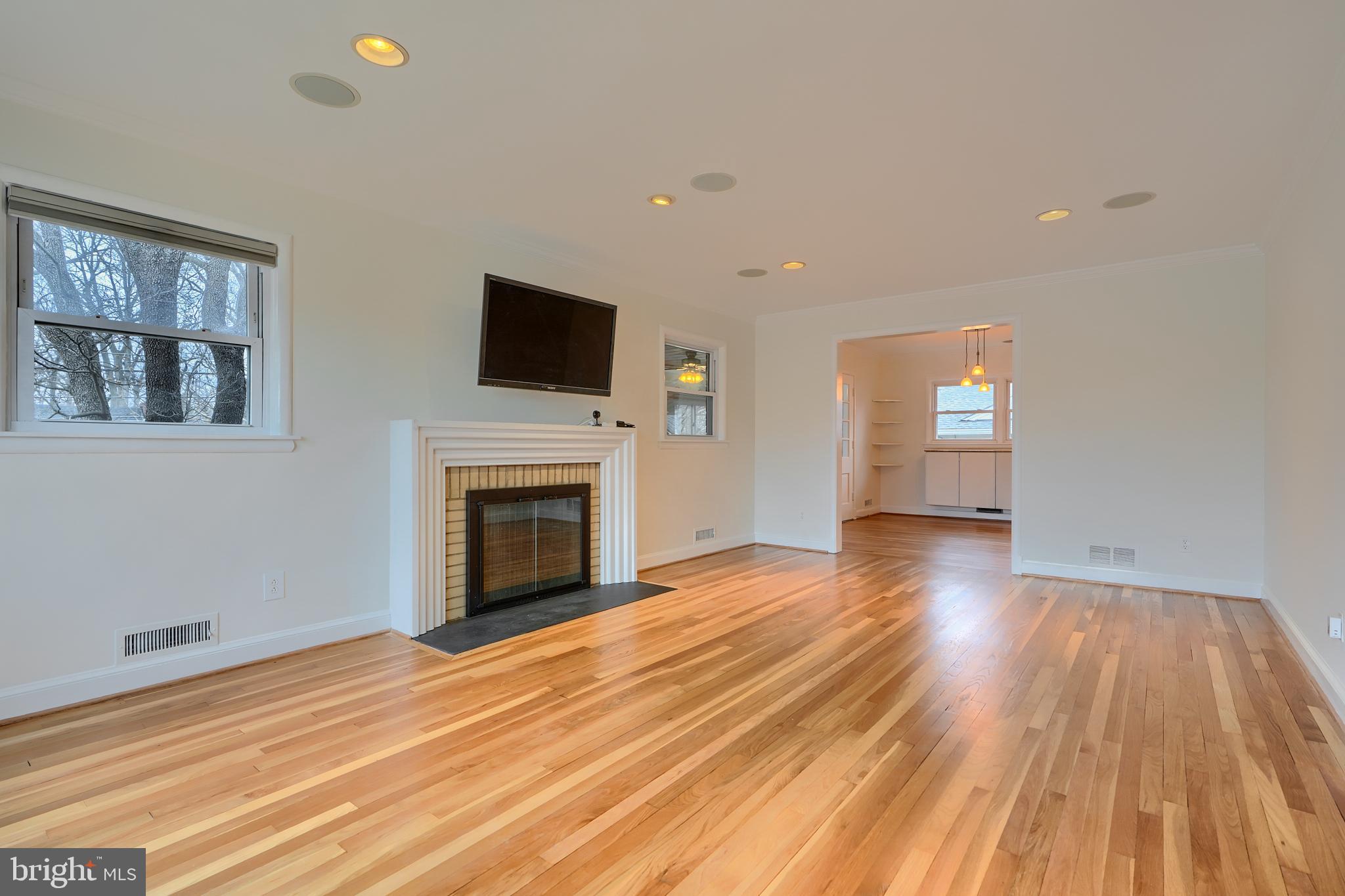 9715 Saxony Road Silver Spring, MD 20910 - Photo 6 of 31 a view of a livingroom with wooden floor and a fireplace