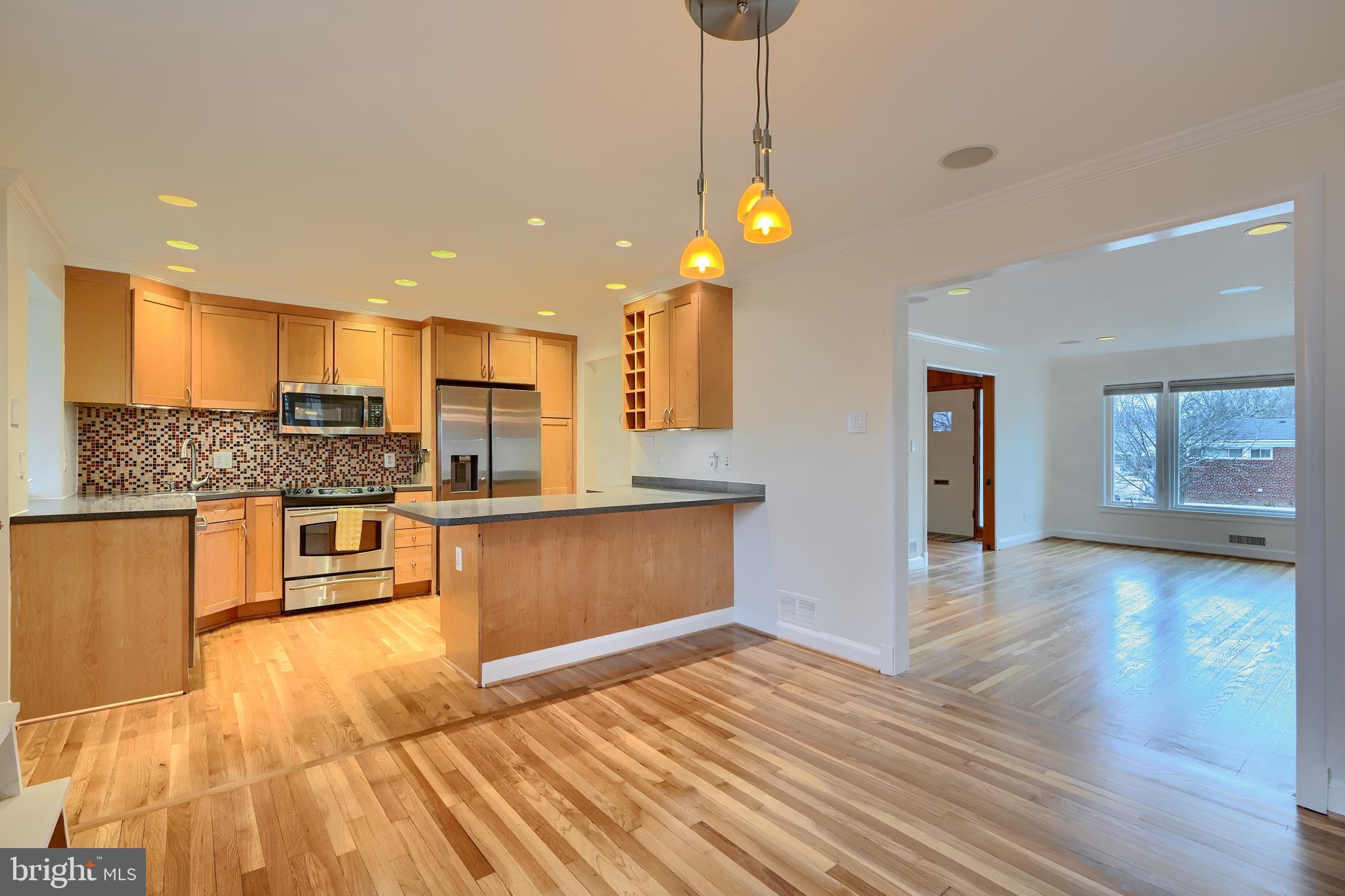9715 Saxony Road Silver Spring, MD 20910 - Photo 9 of 31 a kitchen with stainless steel appliances granite countertop a stove a sink and a refrigerator