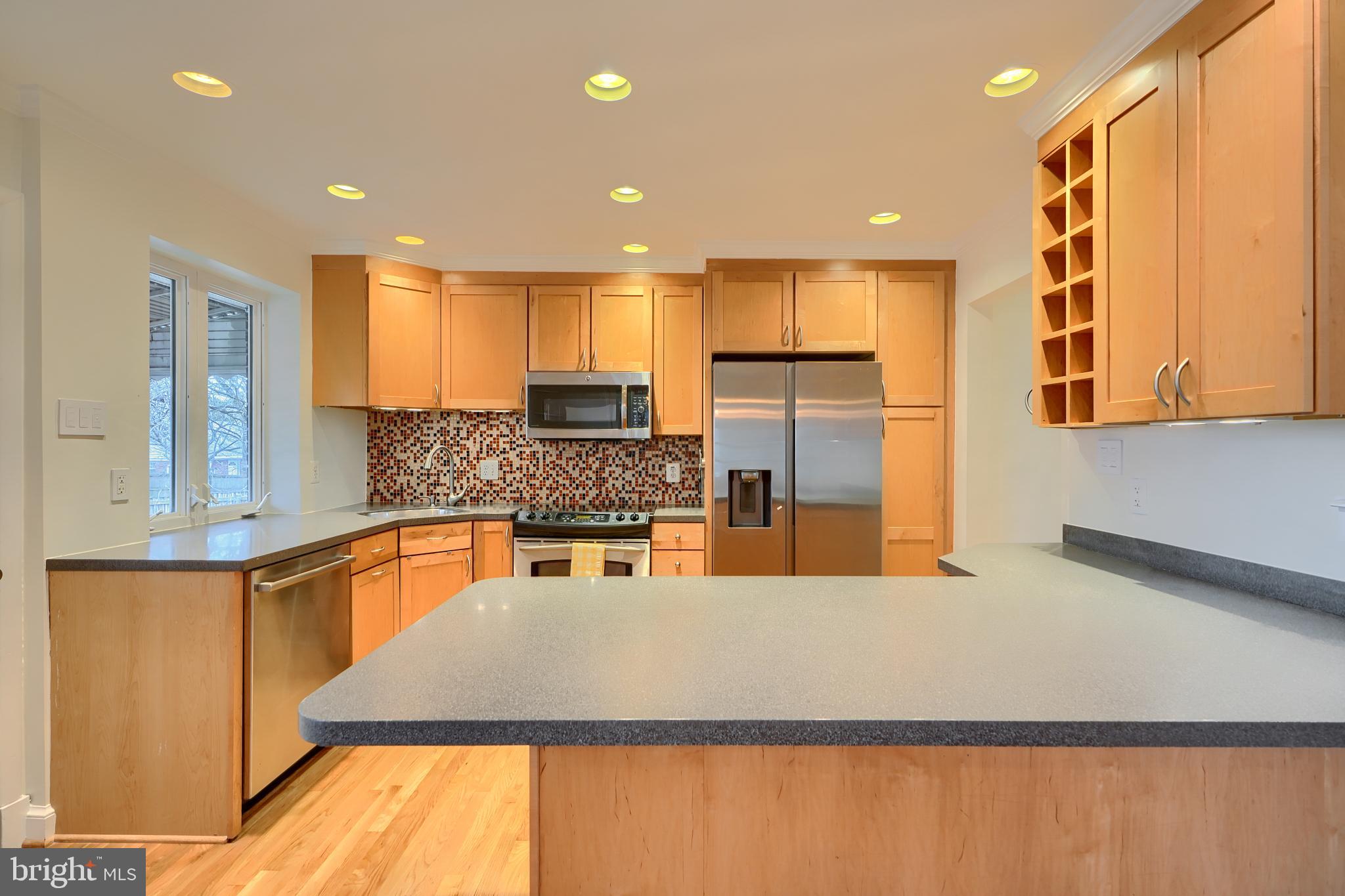 9715 Saxony Road Silver Spring, MD 20910 - Photo 10 of 31 a kitchen with stainless steel appliances granite countertop a sink and a refrigerator