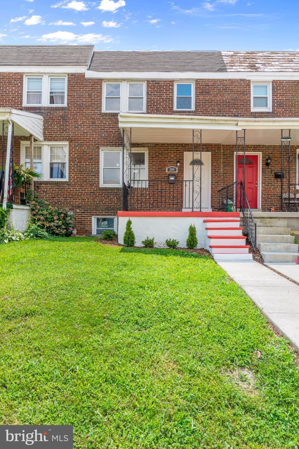 209 West Meadow Road Baltimore, MD 21225 - Photo 2 of 29 front view of a brick house with a yard