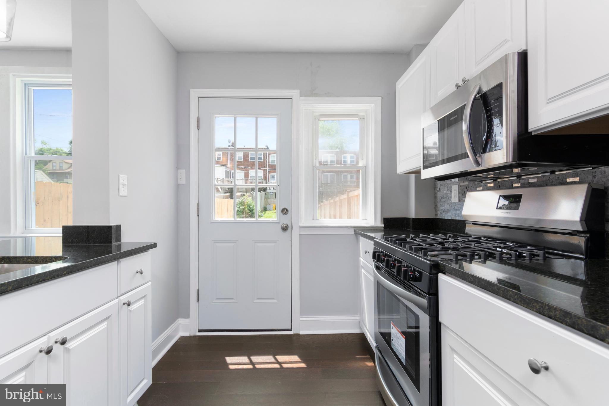 209 West Meadow Road Baltimore, MD 21225 - Photo 9 of 29 a kitchen with stainless steel appliances granite countertop a stove a sink and a microwave