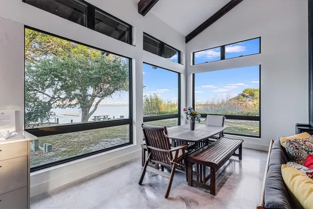 a dining room with furniture and a floor to ceiling window