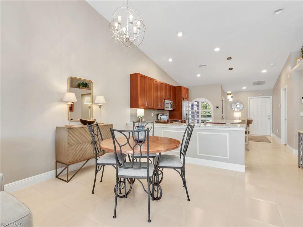 2214 Stacil Circle, Unit 27 Naples, FL 34109 - Photo 10 of 39 a dining room with furniture and a chandelier