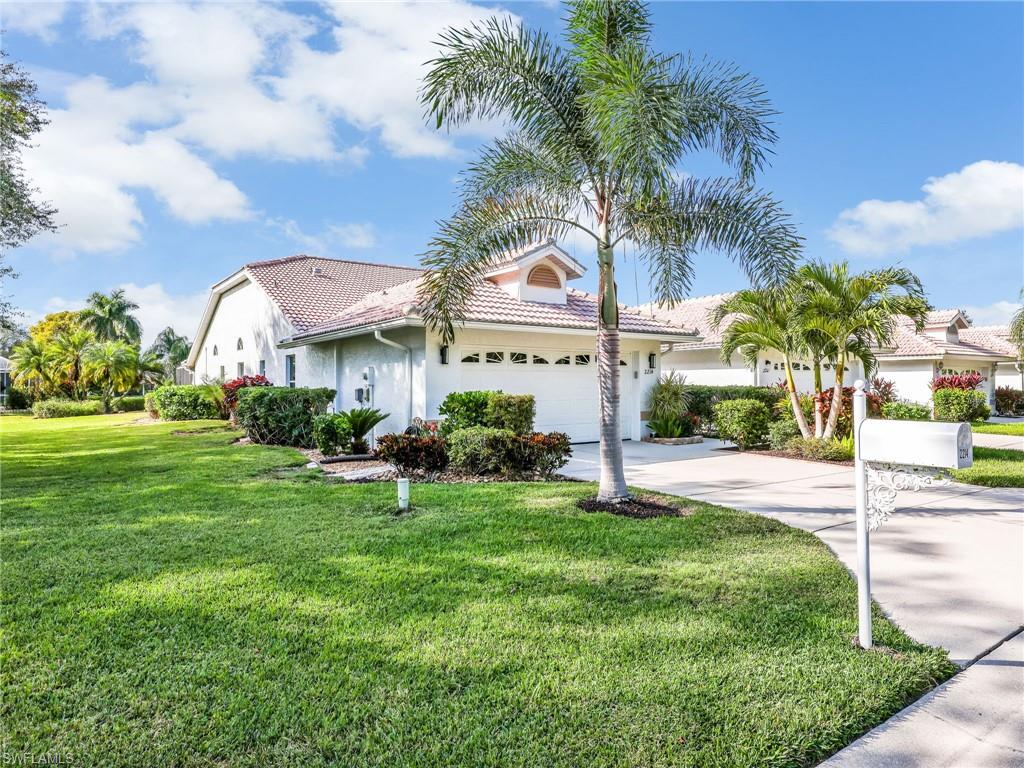 2214 Stacil Circle, Unit 27 Naples, FL 34109 - Photo 2 of 39 a view of a white house with a big yard and potted plants