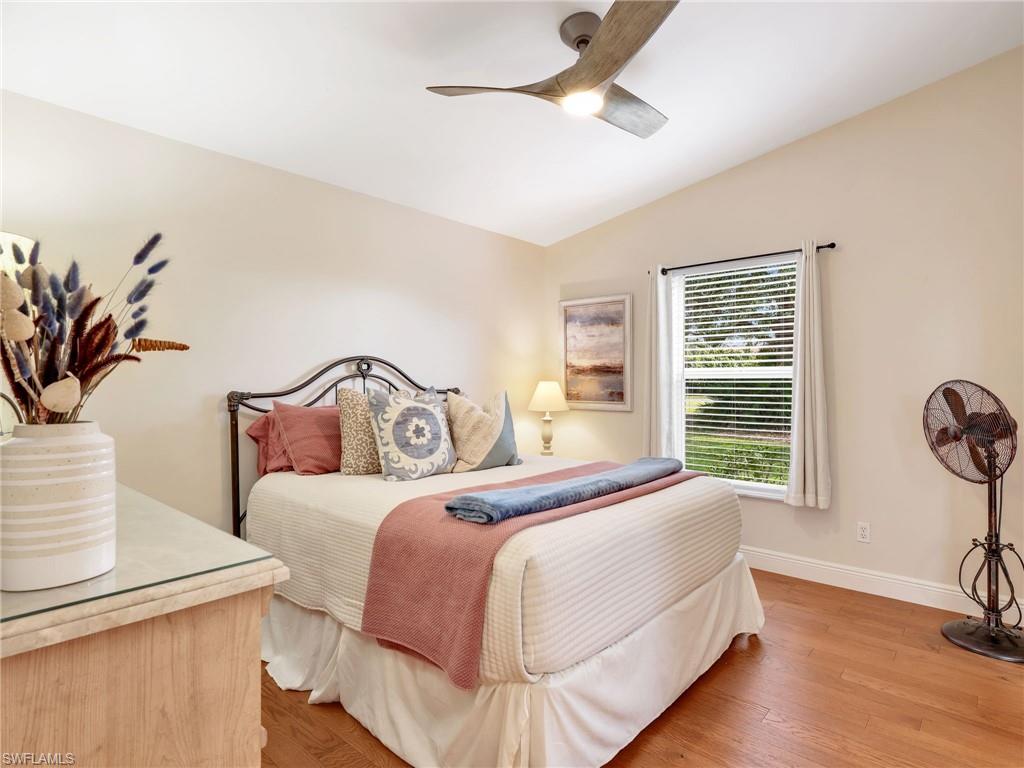 2214 Stacil Circle, Unit 27 Naples, FL 34109 - Photo 22 of 39 a bedroom with bed and window with wooden floor